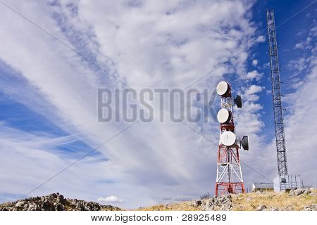 Antena de telecomunicaciones bajo cielo nublado.