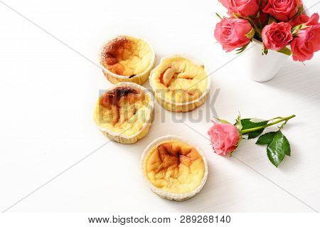 Homemade Small Curd Cakes Or Muffins And Pink Roses On A White Table With Copy Space, Background Fad