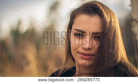 A Beautiful Brunette Girl Posing In A Field On Autumn. Art Photo.