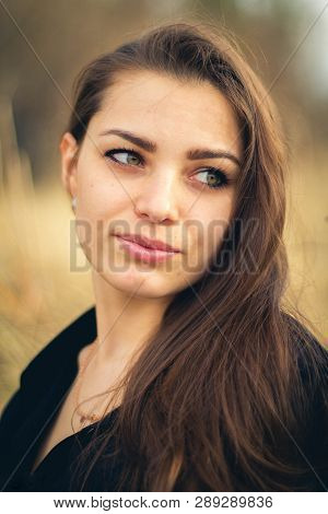A Beautiful Brunette Girl Posing In A Field On Autumn. Art Photo.