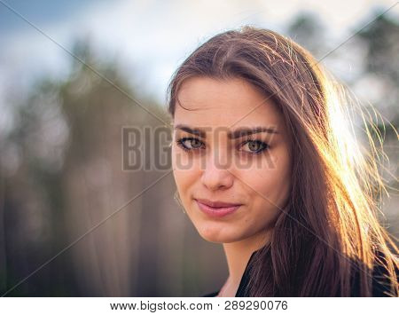 A Beautiful Brunette Girl Posing In A Field On Autumn. Art Photo.