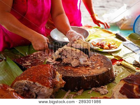 Lechon National Philippine Dish With Waitress Hand. Woman Sells Fried Pork In Asian Country. Traditi
