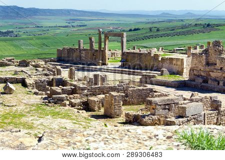 View Of A Section Of The Roman Ruins In Dougga, Tunisia With Landscape In The Background