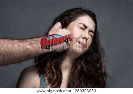 The Concept Of A Car Accident, An Insured Event . A Man's Hand In The Form Of A Car Hits The Girl In