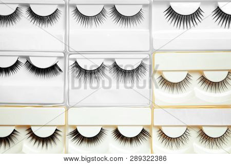 Set With Different False Eyelashes In Packs As Background, Top View