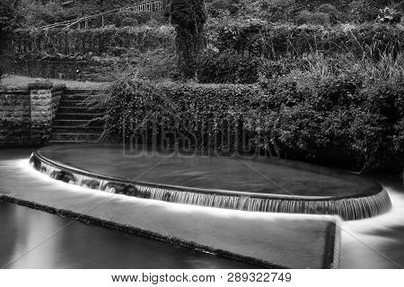Long Exposure Of An Ornamental Waterfall In Cheddar Village In Somerset