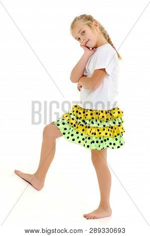 A Cute Little Girl Leaned Against A White Wall. Cyclorama In Studio. Isolated On A White Background.