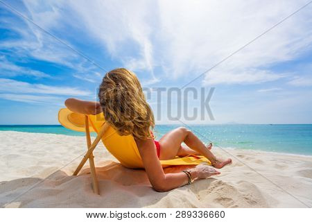 Woman enjoying her holidays on a transat at the tropical beach in Thailand