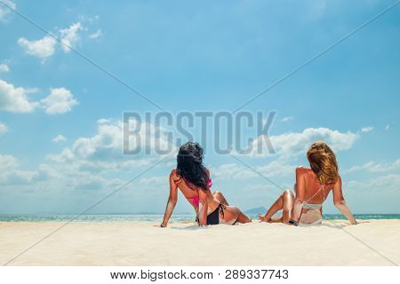 Two Women enjoying their holidays on a transat at the tropical beach in Thailand