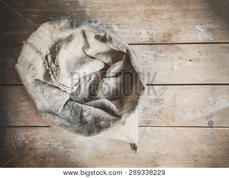 Burlap Bag Of White Wholemeal Flour On Wooden Rustic Boards Background Top View