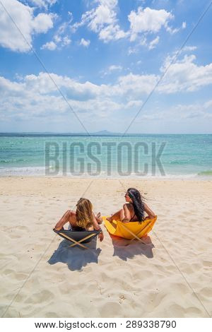 Two Women enjoying their holidays on a transat at the tropical beach in Thailand