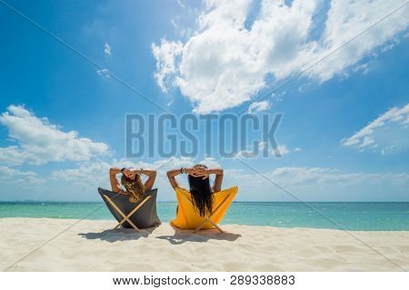 Two Women enjoying their holidays on a transat at the tropical beach in Thailand