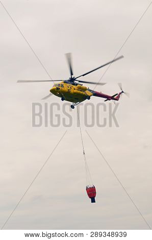 Fire Brigade Helicopter Mil Mi-171 Carrying A Collapsible Bucket For Fire Extinguishing. Aircrafts, 