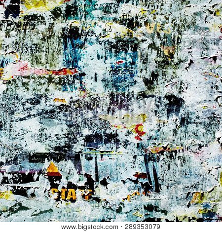 Teared off poster on the wall with colorful layers. Abstract conception.