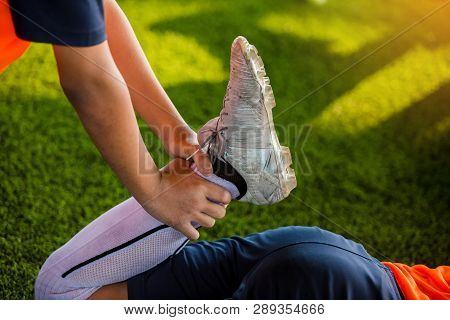 The Footballer Is Holding The Ankle To Stretch The Muscles