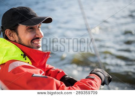 Handsome Man On Yacht Touches White Sail Called Assymetric Spinnaker, Works With Tackle In Sea At Su