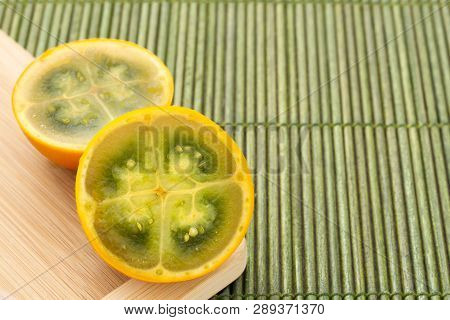 Fruits And Slices Of Lulo Or Naranjilla On The Wooden Table - Solanum Quitoense