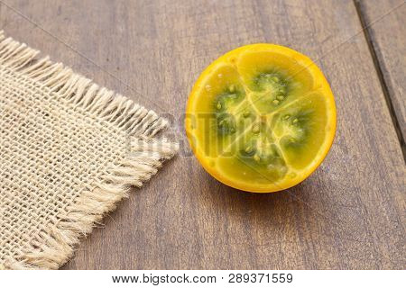 Fruits And Slices Of Lulo Or Naranjilla On The Wooden Table - Solanum Quitoense
