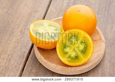 Fruits And Slices Of Lulo Or Naranjilla On The Wooden Table - Solanum Quitoense