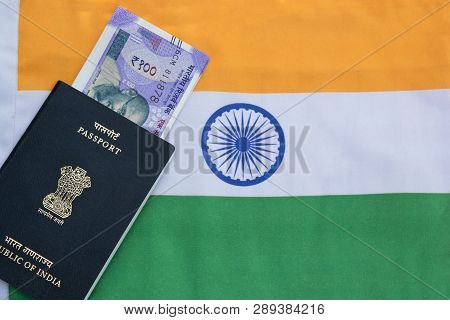 Closeup Of Indian Passport With Indian Currency On Indian Flag As A Background