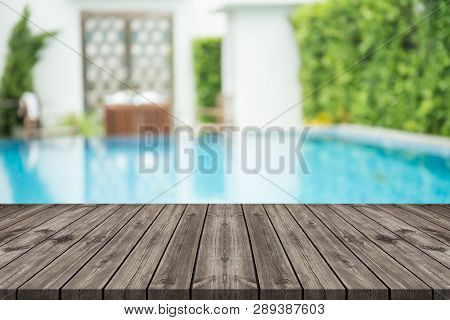 Empty Wooden Table In Front With Blurred Background Of Swimming Pool