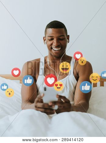Black man watching a live streaming on his bed