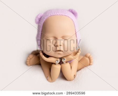 Plastic mannequin of baby, made for posing, in frog stand, isolated