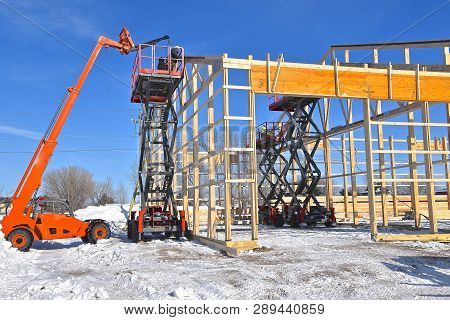 Hoists Lifts, And Scissor Jacks Are Being Used In The Construction Of A New Industrial Warehouse.