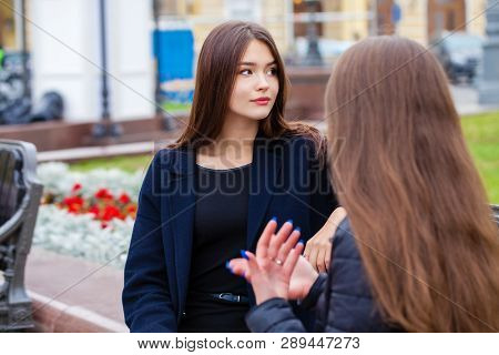 Two happy young women walking in autumn park, outdoors