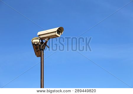 Outdoor Surveillance Camera On A Pole Isolated On Clear Blue Sky. Cctv Camera, Concept For Security,