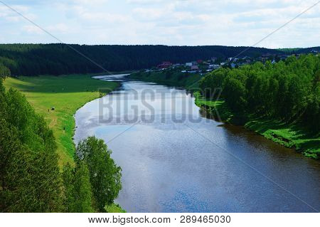 Aerial View Over Still River With Green Forest On Shores