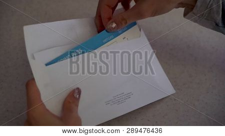 Close Up For Woman Hands Opening The Envelope And Taking The Ticket And The Document Out. Female Han