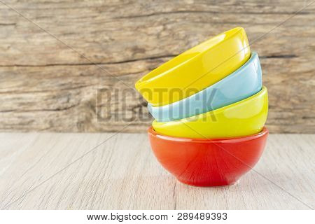Ceramic Bowl Assorted Colors On Wooden Background
