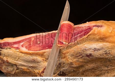Close-up Of A Knife Cutting A Spanish Serrano Ham