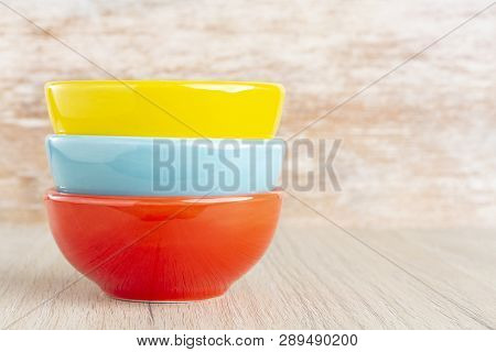 Ceramic Bowl Assorted Colors On Wooden Background