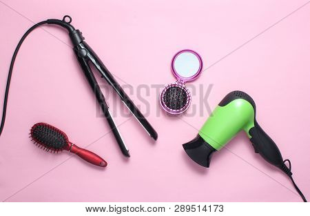 Hairdryer, Curling Iron, Hairbrush, Mirror On Pink Pastel Background. Beauty And Fashion Objects For