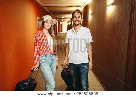 Couple with suitcases checking into the hotel