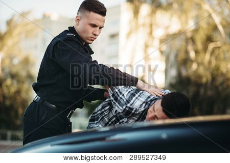 Police officer arrests the driver violator on road