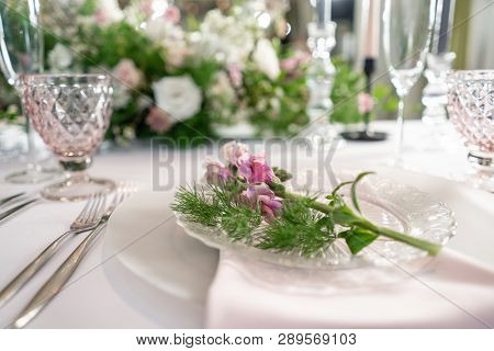 Closeup Table Setting With Plates And Tableware, Adorned With Flowers. Floral Decoration For Wedding