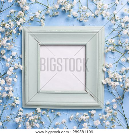 Empty  Vintage  Green Frame And  Fresh White Gypsofila  Flowers On Blue Textured Background. Top Vie