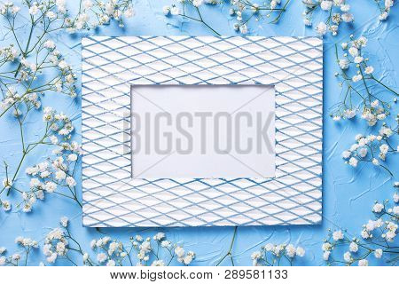 Vintage Empty Frame And  Fresh White Gypsofila  Flowers On Blue Textured Background. Top View. Flat 
