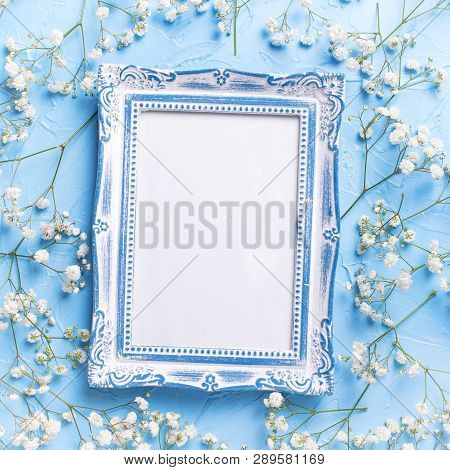 Empty  Vintage Frame And  Fresh White Gypsofila  Flowers On Blue Textured Background. Top View. Flat