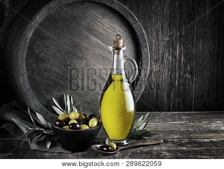 Bottle Of Extra Virgin Healthy Olive Oil With Barrel Background