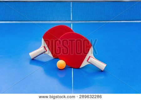 Pingpong Rackets And Ball And Net On A Blue Pingpong Table