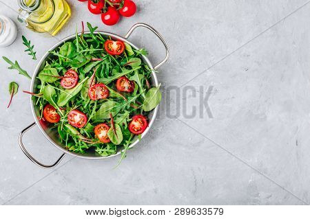 Fresh Salad With Green Leaves Of Arugula, Lettuce, Spinach, Beets And Tomato On A Gray Stone Backgro
