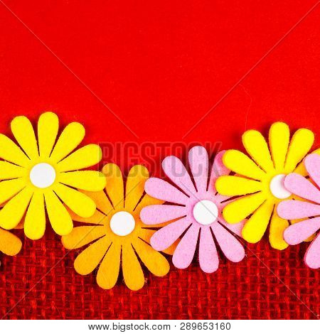 Birthday Gift Card With Red  Ribbon Decoration And Multicolor Flowers Laying On Red Background