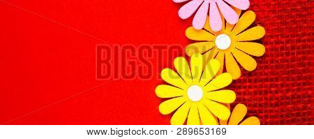 Birthday Gift Card With Red  Ribbon Decoration And Multicolor Flowers Laying On Red Background