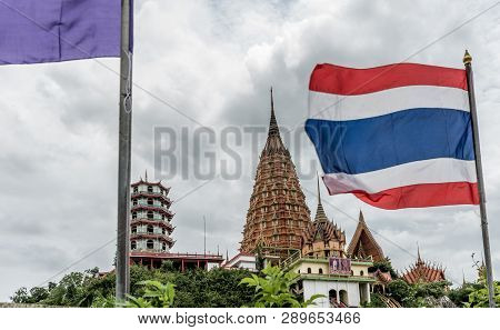 Wat Tham Suea On A Hill With Flags In Foreground And Clouds In The Background