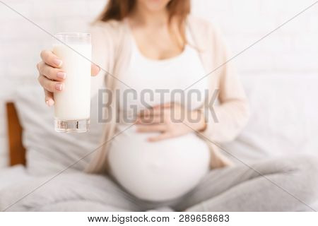 Lactation And Breastfeeding Concept. Pregnant Woman Offering Glass With Fresh Milk On Camera, Concep