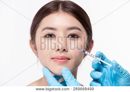 Surgery Concept. The Doctor Cosmetologist Makes The Rejuvenating Facial Injections Procedure For Tig